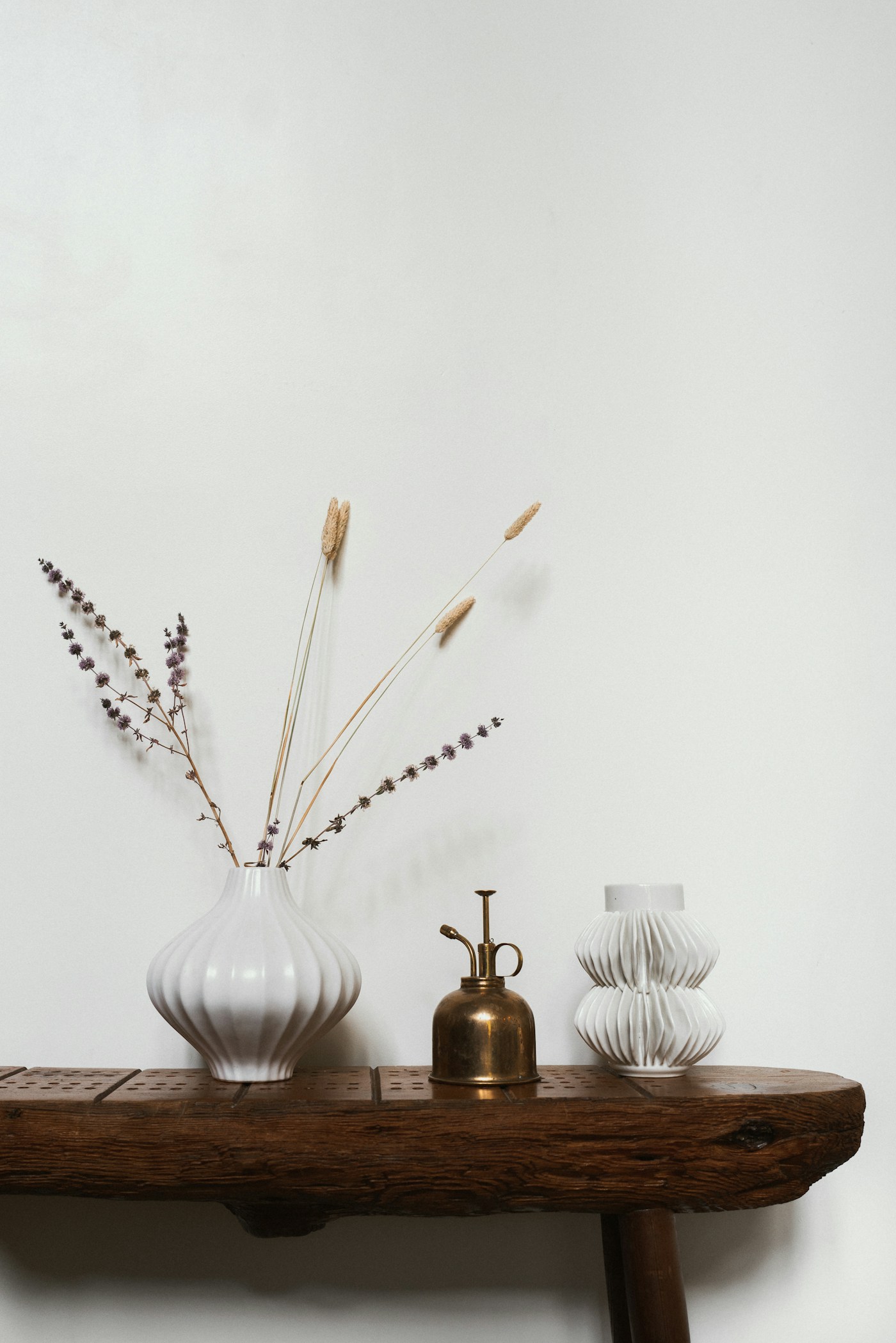Vase blanc strié avec fleurs séchées
